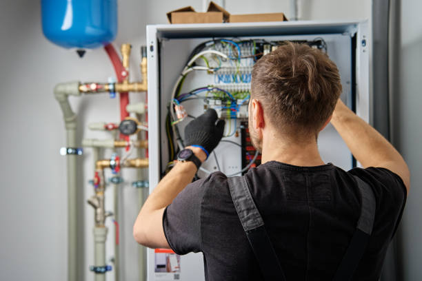 Elektriker arbetar i teknikrum med rör och elskåp